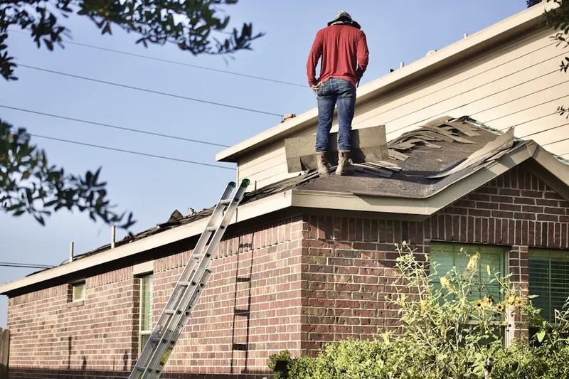 Professional roofer working on a residential roof in Glen Oaks Manor